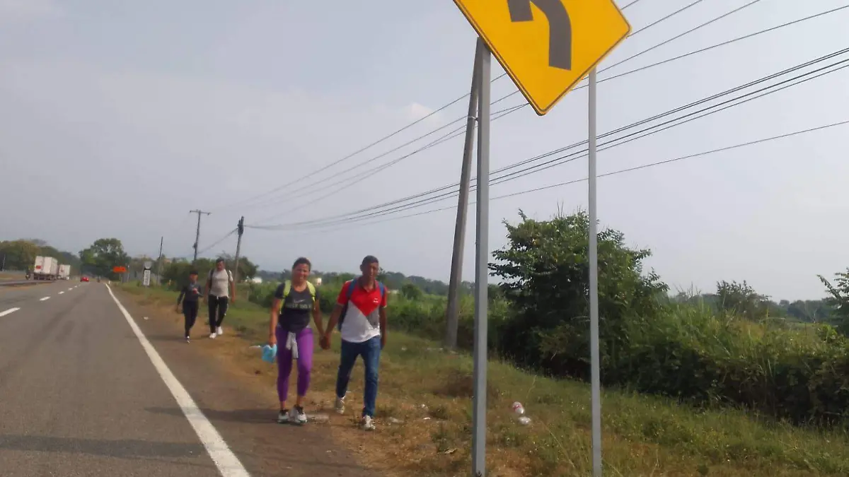 migrantes caminando en carretera